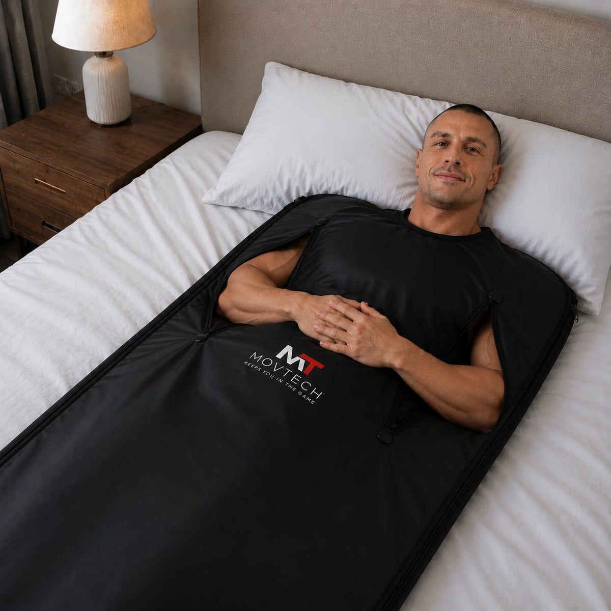 Férfi pihen az ágyon a Movtech Infra Sauna Blanket szaunatakaróban