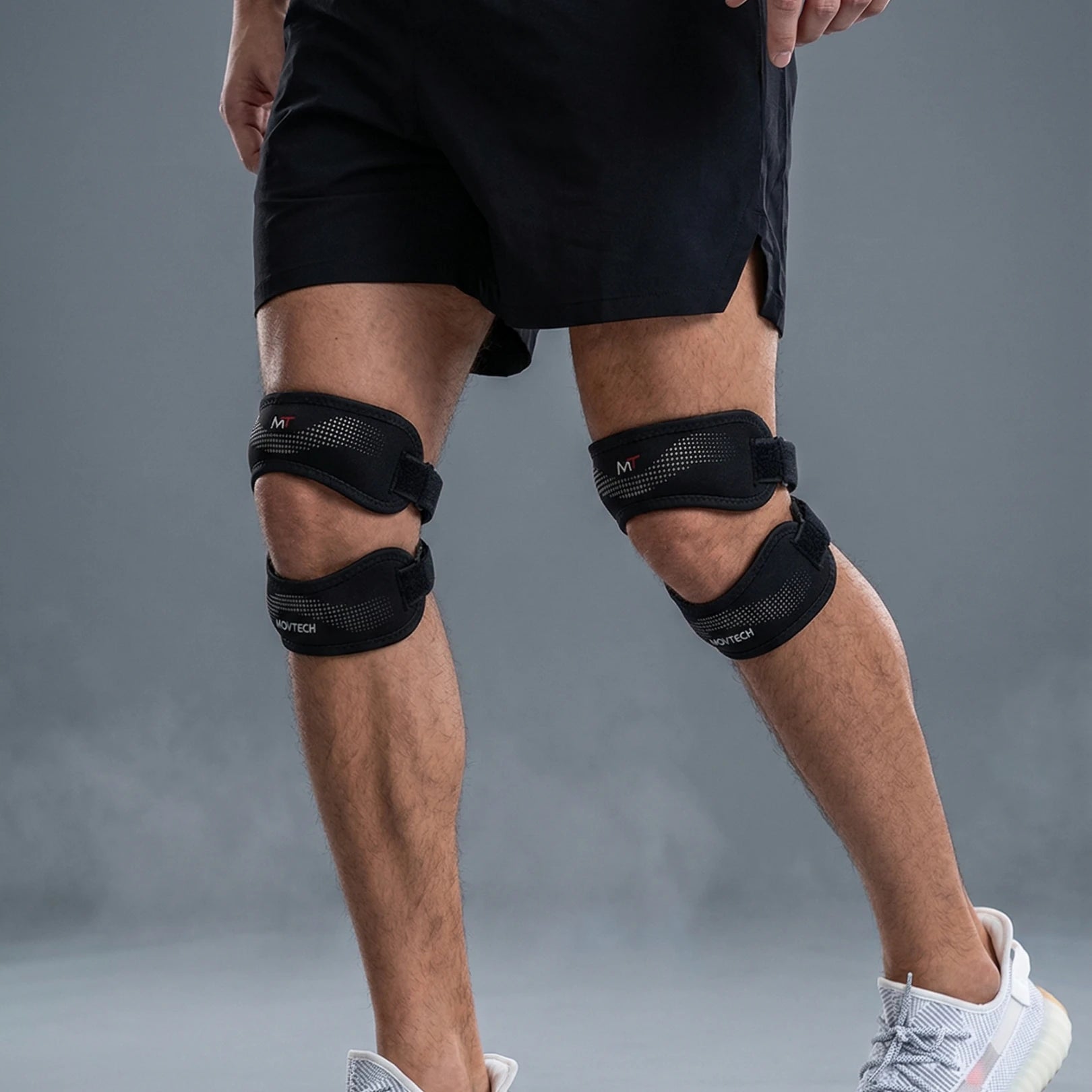 Movtech Knee Pro térdrögzítő mindkét térden, stúdiófelvétel szürke háttér előtt