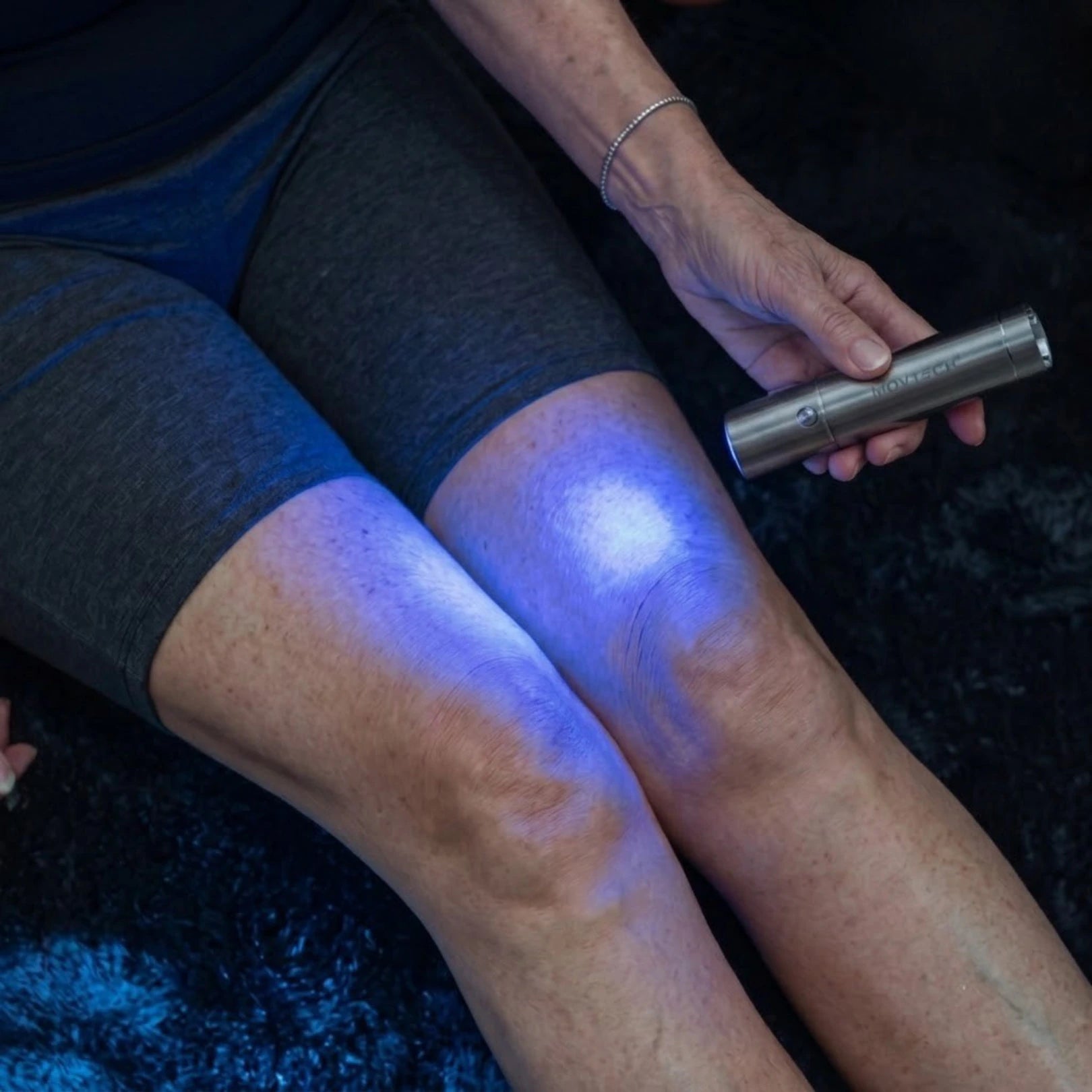 Movtech Red Light Lamp kék fénnyel a térden, ülő helyzetben