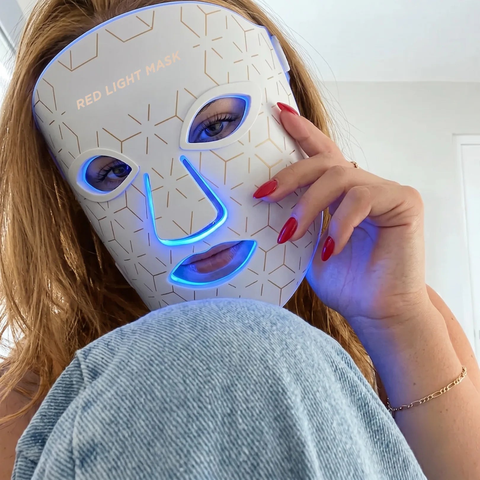 Fiatal nő viseli a Movtech Red Light Mask LED arcmaszkot kék fénnyel, közeli felvétel